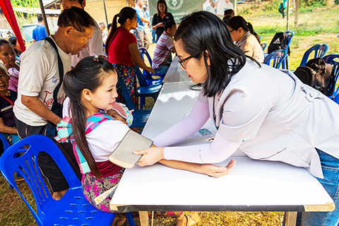 A healthcare worker is checking the blood pressure of a little girl. 