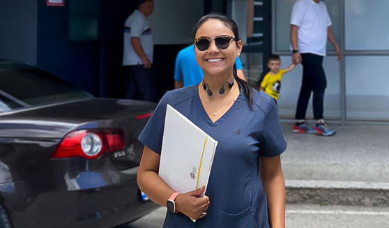 Melissa Kosovo standing in front of a medical center, holding a file. 