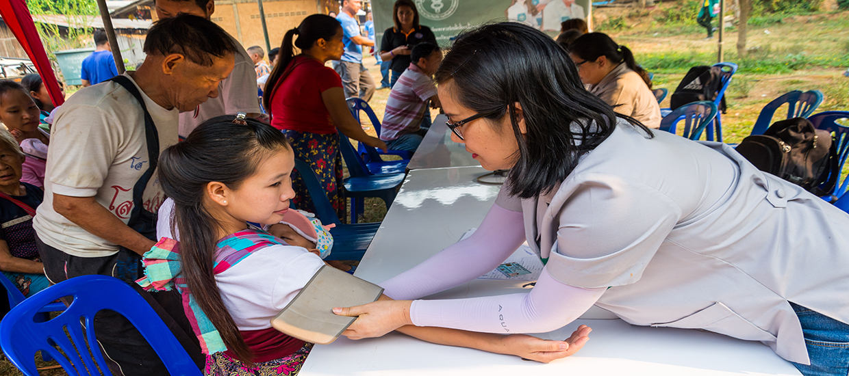 An image of a doctor taking a young woman's blood pressure.