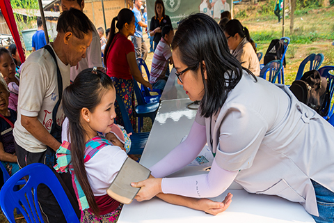 An image of a nurse taking the blood pressure of a young woman.