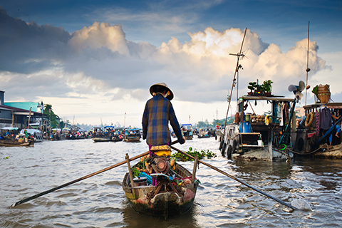 A stock photo of a boatman sailing into a fishing village.